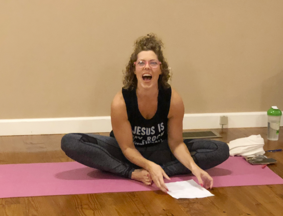 GG teaching yoga, sitting on the floor laughing hysterically