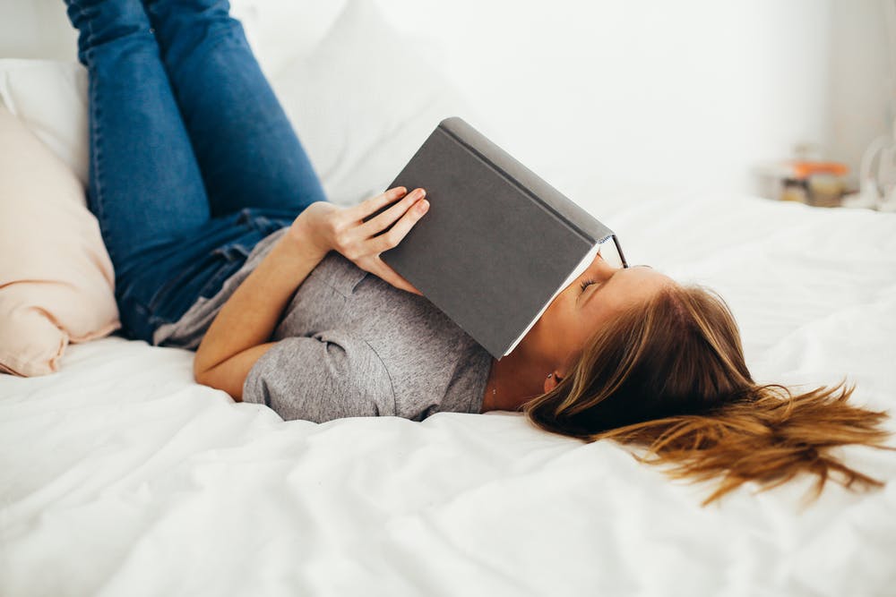 Woman lying down reading a book