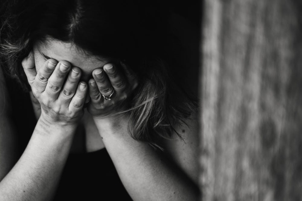 woman with her head in her hands, looking frustrated or sad